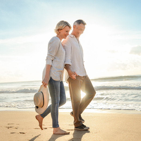 older couple walking on beach